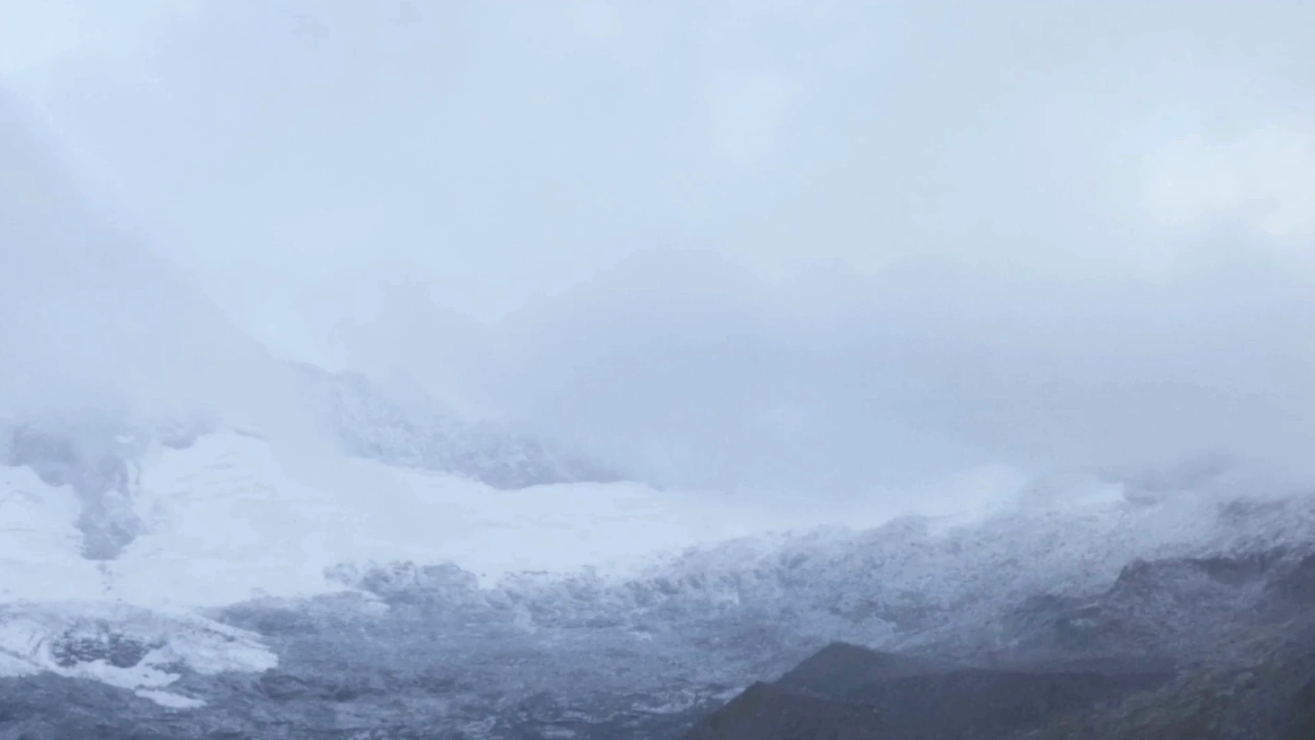 Clouds reveal the snow-covered mountain landscape of Tauern, Austria.
